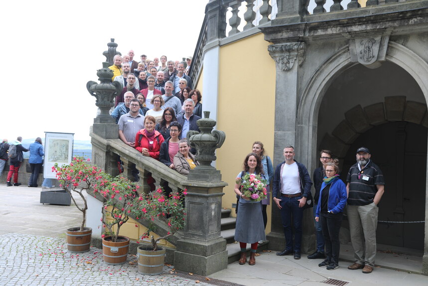 Die Teilnehmerinnen und Teilnehmer des Workshops haben sich zum Foto auf einer Wendeltreppe auf der Festung Königstein versammelt.