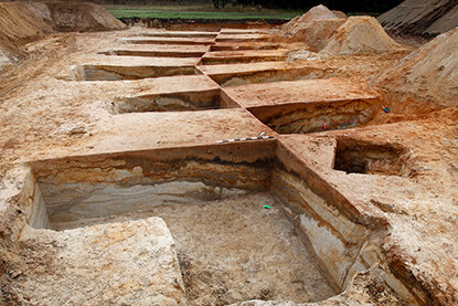 Die schachbrettartig angelegten Quadranten dienen der Gewinnung von Erdprofilen, in denen sich die archäologischen Schichten abzeichnen.