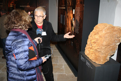 Projektleiterin »Ziel-3 ArchaeoMontan« Dr. Christiane Hemker präsentiert eine unter Tage gefundene mittelalterliche Einpickung, die eine abstrakte menschengestaltige Figur darstellt.