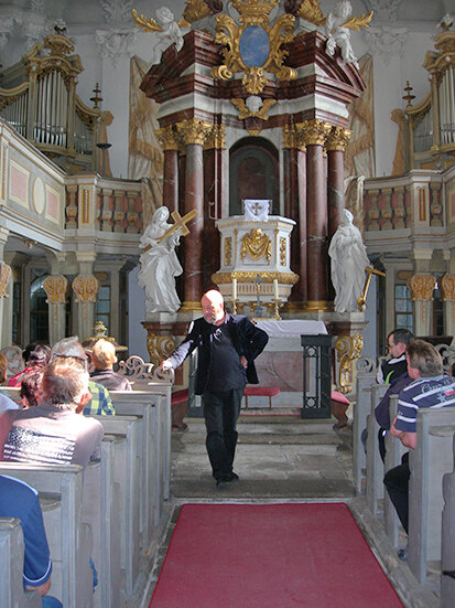 Pfarrer Heiner Sandig begrüßt die Radler in der Schlosskirche Tiefenau.