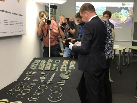 Der Ministerpräsident Michael Kretschmer betrachtet den 3000 Jahre alten Hortfund