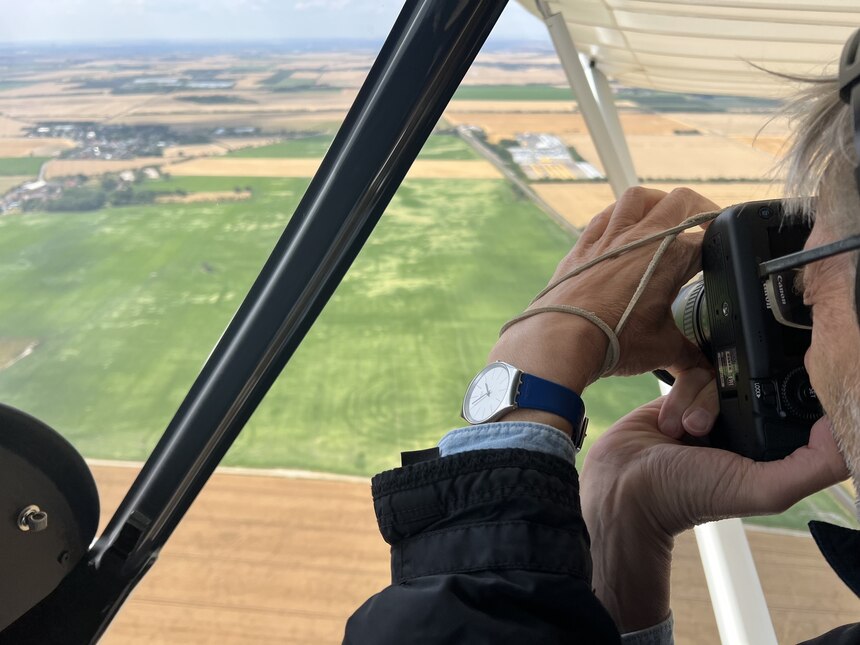 Der Luftbildarchäologe Dr. Ronald Heynowsly vom LfA fotografiert die Kreisgrabenanlage von Kyhna aus dem Flugzeug.