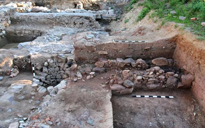 Rechts Fundamente eines zweiphasigen Gebäudes aus dem 15. Jahrhundert. Im Hintergrund zugehöriges Hofplaster; links Schacht eines mutmaßlich jüngeren Brunnens.